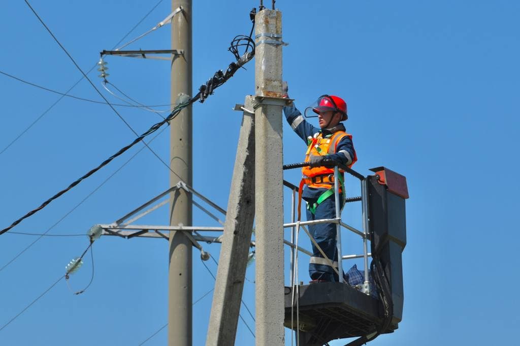 A man standing near an electric post