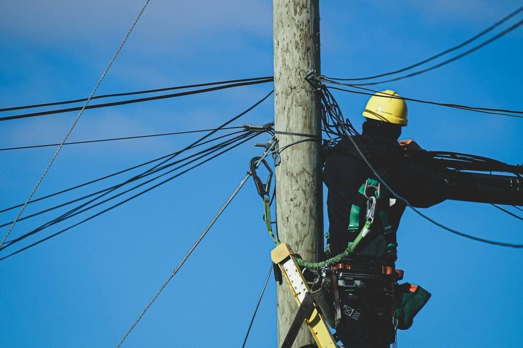 An electrician working on an electric post