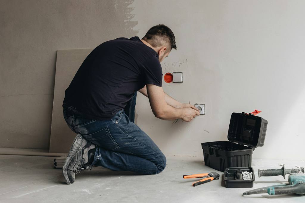 A man working on a wall socket