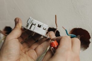 A person holding an electrical