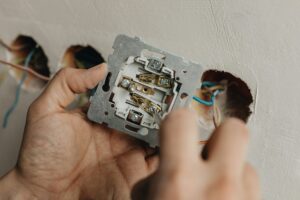 A person fixing a light switch